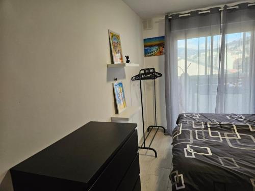 une chambre avec un lit, une commode et une fenêtre dans l'établissement L'escapade vers le bien-être, à Nice