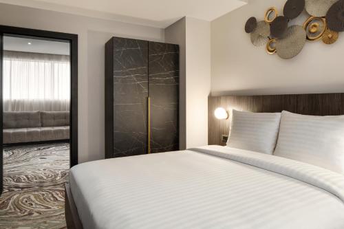 a bedroom with a white bed and a closet at Ramada by Wyndham Bucharest Otopeni Airport in Otopeni