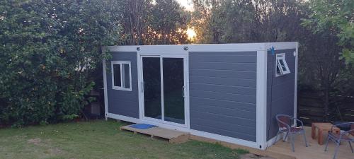 a blue and white shed with a table and chairs at Haley's cabin in Tauranga