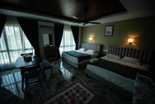 a hotel room with two beds and a desk at MKB Homestay - 2 X King Bed Studio Room with view & FREE parking in Shah Alam