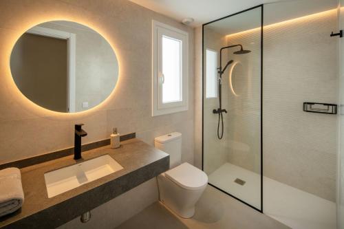 a bathroom with a toilet and a sink and a shower at Panasco Suites in Arrecife