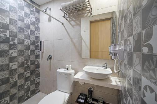 a bathroom with a white toilet and a sink at Hotel Neo Plus Airport Jakarta in Tangerang