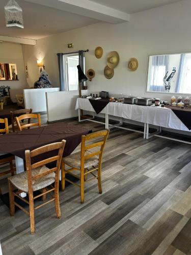 a dining room with a table and chairs at Hôtel Le Soleil Couchant in Saint-Pierre