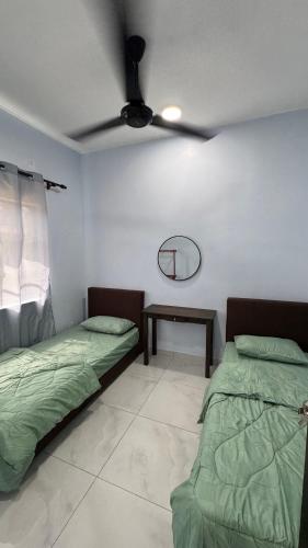 a room with two beds and a ceiling fan at Mama Homestay Sri Damai in Kuantan