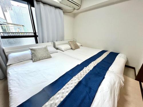 een groot bed in een kamer met een raam bij 大国町駅徒歩3分 なんば駅1駅 最大4名 ロイヤル507 in Osaka