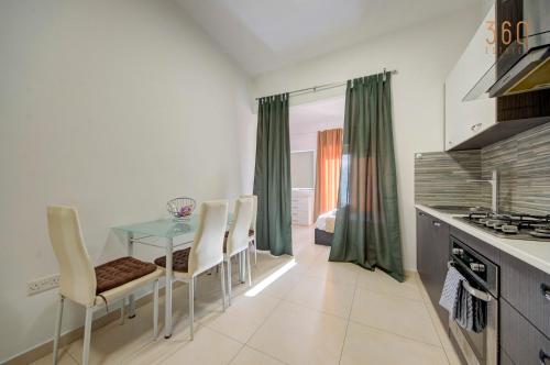 a kitchen with a table and chairs in a room at Cozy Studio home with Stunning Mosta Dome Views by 360 Estates in Mosta