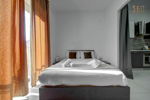 a bedroom with a large bed and a large window at Cozy Studio home with Stunning Mosta Dome Views by 360 Estates in Mosta