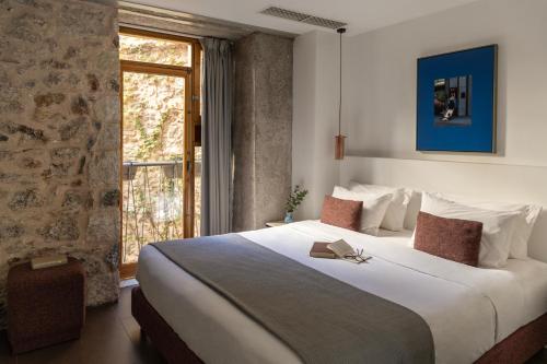 ein Schlafzimmer mit großem Bett und Fenster in der Unterkunft Asomaton by Oniro in Athen