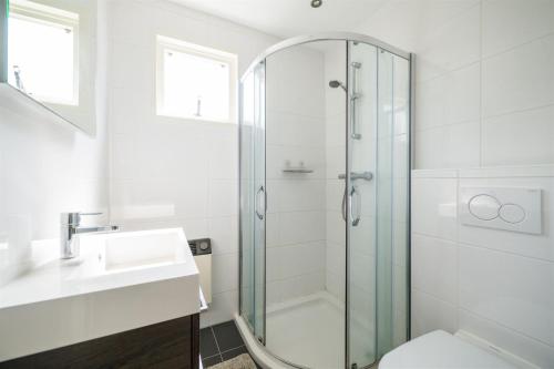 un baño con ducha y lavabo en Strand 104, en Hollum