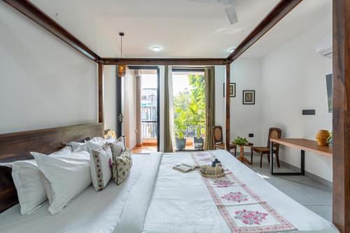 a large bedroom with a large bed with white pillows at Alaya Stays Ramalaya - Room with balcony in Jaipur