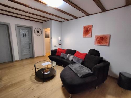 a living room with a black couch and a table at Heimelige 4 Zimmerwohnung im schönen Val Poschiavo in Prada