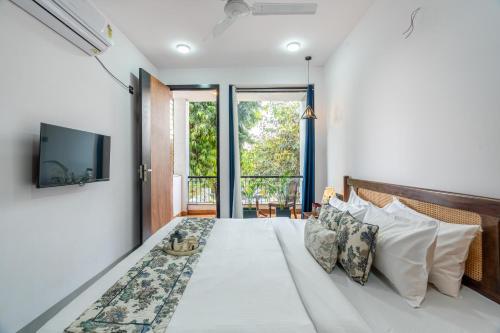 a bedroom with a large bed with a large window at Alaya Stays Ramalaya - Room with balcony in Jaipur