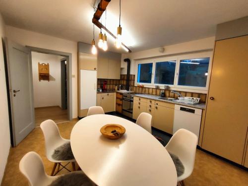 a kitchen with a table and chairs in a room at Heimelige 4 Zimmerwohnung im schönen Val Poschiavo in Prada