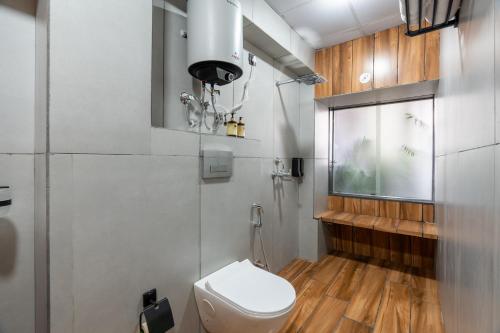 a bathroom with a white toilet and a window at Alaya Stays Ramalaya - Room with balcony in Jaipur