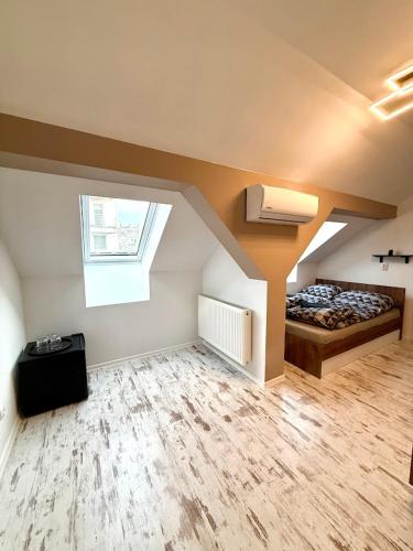 a attic room with a bed and a window at Kuriózum vendégház in Szeged