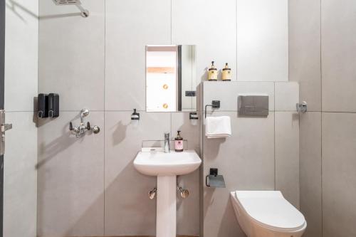 a bathroom with a sink and a toilet and a shower at Alaya Stays Ramalaya - Room with balcony in Jaipur