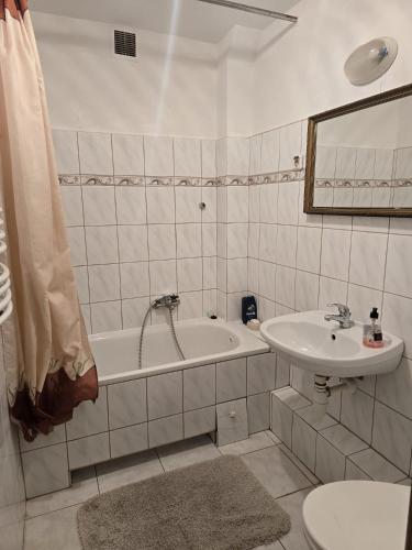 a bathroom with a sink and a tub and a toilet at Pensjonat Feliksów in Wiskitki