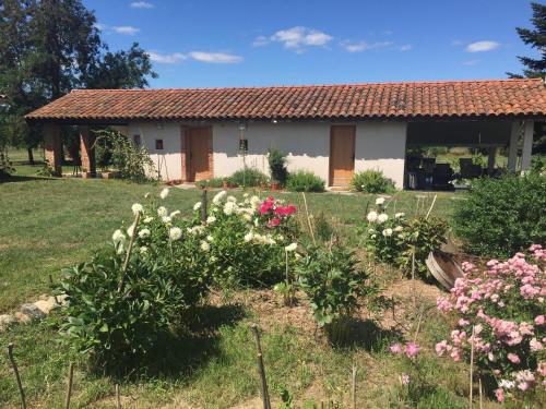 un jardin devant une maison avec des fleurs dans l'établissement Location gîte 4 personnes Mazères - La Petite Maison, à Mazères