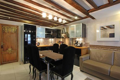 une cuisine avec une table, des chaises et un canapé dans l'établissement Appartement spacieux au cœur de Paris 75 m² avec vue sur la ville, à Paris