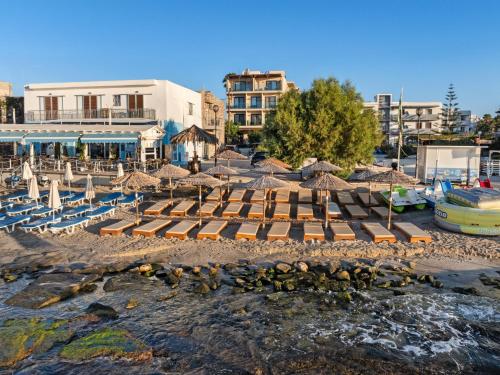 a group of umbrellas and chairs on a beach at Cabana Blu Lifestyle Boutique Hotel & Suites in Kardamaina