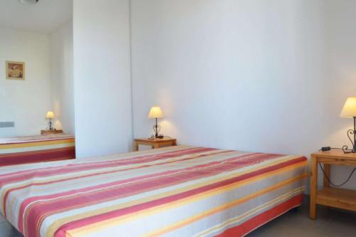 une chambre avec un lit avec deux tables et deux lampes dans l'établissement NP610-B230 Appartement 3 pièces Narbonne Plage, à Narbonne-Plage