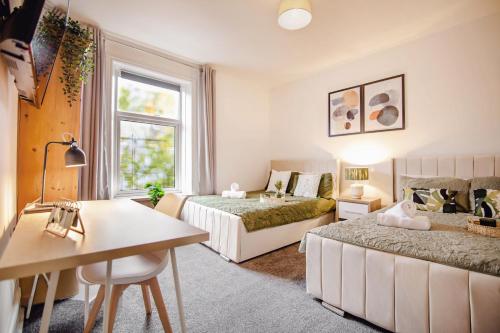 a bedroom with two beds and a table and a desk at Modern Central Luxury Home with Hot Tub Sauna 12PPL in Sheffield