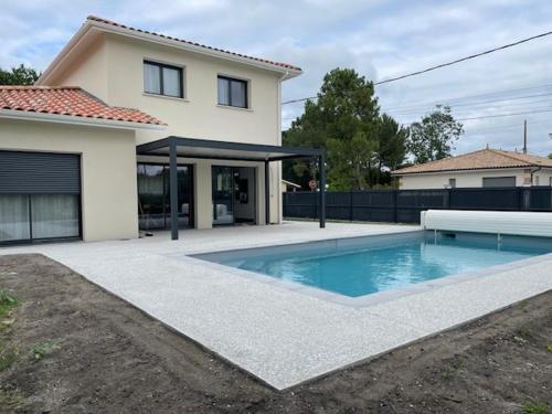 une maison avec une piscine devant une maison dans l'établissement Villa L'Evasion, neuve, 4 chambres, 8pers, piscine chauffée, à Andernos-les-Bains