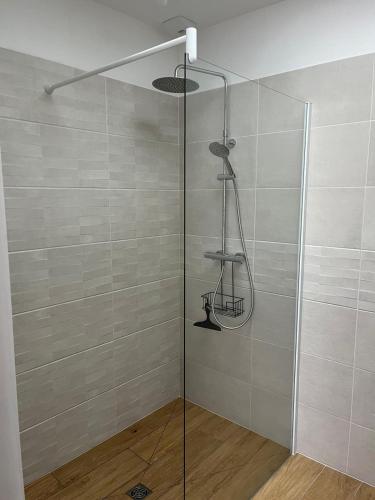 une douche avec une porte vitrée dans une salle de bain dans l'établissement Villa L'Evasion, neuve, 4 chambres, 8pers, piscine chauffée, à Andernos-les-Bains