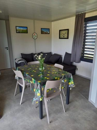 - une table à manger avec des chaises et un canapé dans l'établissement Charmant Cottage, à Saubrigues