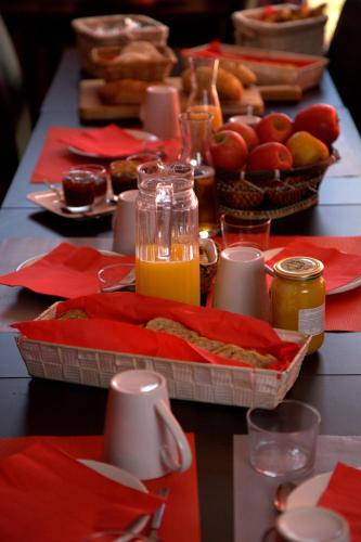 une longue table recouverte de serviettes rouges et de jus d'orange dans l'établissement DOMAINE DU SIESTOU WINE RESORT & spa, à Laure-Minervois