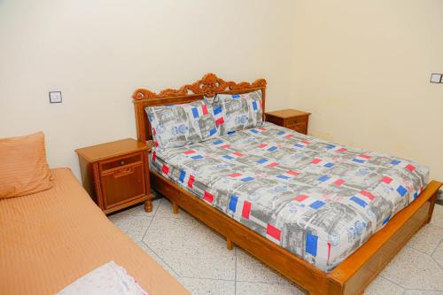 a bedroom with a bed with a wooden frame and two tables at Wadahab House An Ideal Retreat for Families and Friends in Er Rachidia