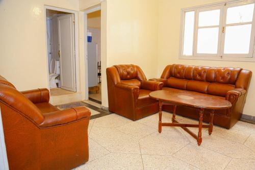 a living room with brown leather furniture and a table at Wadahab House An Ideal Retreat for Families and Friends in Er Rachidia