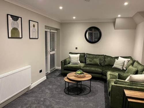 a living room with a green couch and a table at 6 Bedroom Luxury Home in Olton