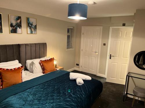 a bedroom with a bed with a blue blanket and orange pillows at 6 Bedroom Luxury Home in Olton