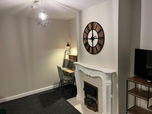 a living room with a clock on the wall and a desk at 6 Bedroom Luxury Home in Olton