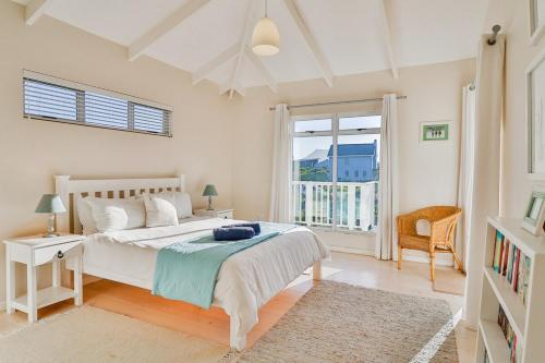 ベティーズ・ベイにあるTidesのベッドと大きな窓のある寝室