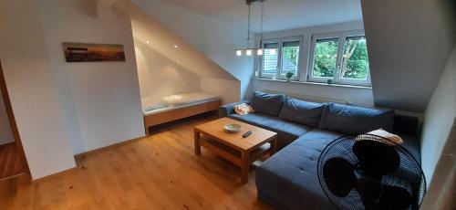 a living room with a blue couch and a table at Ferienwohnung zum IRRSEE 79 Mondseeland in Zell am Moos