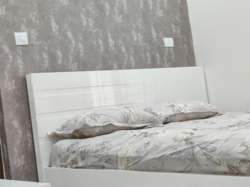 a white bed with two pillows on top of it at Aayushman Luxury Homes in Sarjāpur