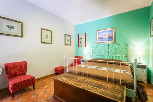 a bedroom with a bed and a red chair at Villa Felice in Giardini Naxos
