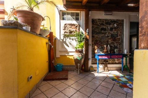a kitchen with a yellow door and a table with plants at Villa Felice in Giardini Naxos