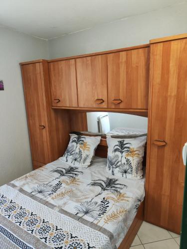 une chambre avec un lit avec une armoire en bois dans l'établissement Appartement T2 Duplex 4 P 35m2 avec parking, proche mer, au Grau-du-Roi