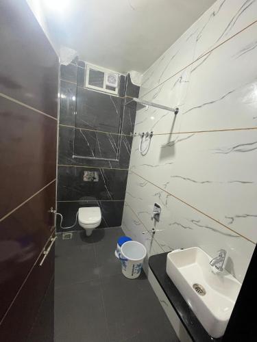 a bathroom with a sink and a toilet at Yashomati Hotel in Maheshwar
