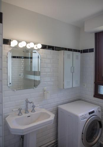 une salle de bain avec une machine à laver et un lavabo dans l'établissement Rameau, à Hossegor