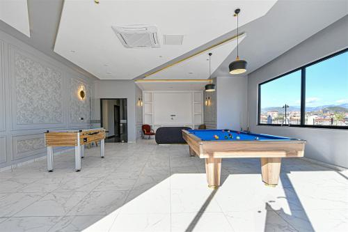 a living room with a pool table and two tables at Sıfır Muhteşem Havuzlu Aileye Özel 1e1 Rezidans in Alanya