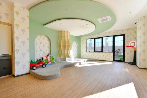 a living room with a green ceiling and a toy car at Sıfır Muhteşem Havuzlu Aileye Özel 1e1 Rezidans in Alanya