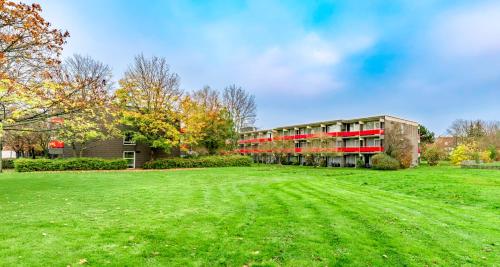 a building with a large field in front of it at PLAZA INN Goslar in Goslar