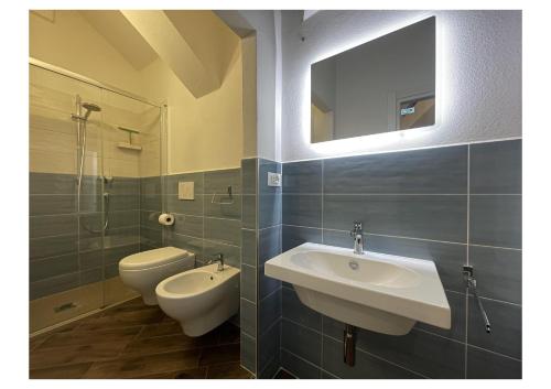 Un baño con lavabo, inodoro y espejo. en LHE Casa Bufalini, en Cesena