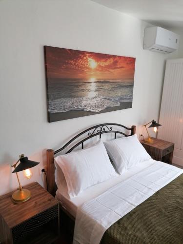 a bedroom with a bed and a painting on the wall at Stephany's Skyline Studio in Parikia
