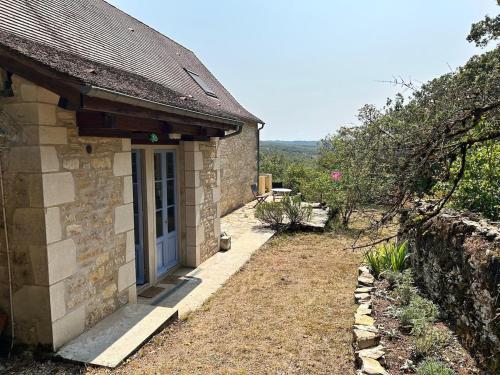 une maison en pierre avec une porte bleue et une cour dans l'établissement Charming detached house in beautiful Calvignac, à Calvignac