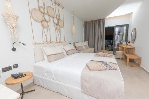 a white bedroom with a large bed and a table at Cabana Blu Lifestyle Boutique Hotel & Suites in Kardamaina